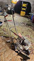 Full view of Briggs & Stratton gas powered edger showing frame, engine, wheels, and handlebar with grips.