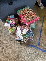 Stack of assorted jigsaw puzzle boxes including 48, 300, 500, and 1000 piece counts with various themes visible like Mickey Mouse and flowers.