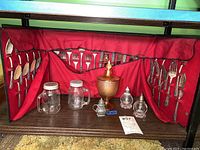 Full display of silverplate flatware in red-lined case, five glass shakers, and carnival glass bowl