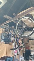 Full side view of the full bicycle hanging in storage showing frame, tires, and handlebars.