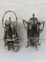 Photo showing the vintage 1879 hot water/coffee urn, the Reed & Barton tilting water pitcher on stand, and a matching goblet arranged together.