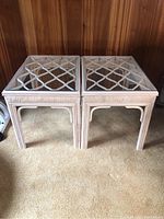 View of the pair of cane framed end tables with clear glass tops and lattice cane design beneath.