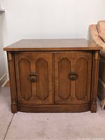 Full view of vintage wooden end table showing front double doors and overall shape