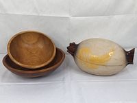 Three kitchen items: ceramic chicken clay pot with painted design and two nested wooden bowls.