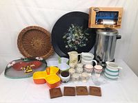 Full lot of kitchen items including coffee maker, egg cups, trays, baskets, pitchers, and mesh cover with bees.