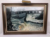 Full frontal view of framed oil painting depicting river runoff and bridge.