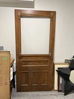 Full view of the antique solid wood door showing its rectangular shape and detailed panel and frame design.