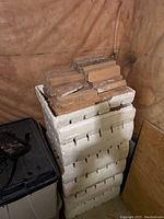 Filled styrofoam container stacked with slim reddish-brown clay bricks.