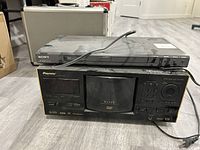 Photo showing Sony DVD player on top of Pioneer Elite DV-F07 DVD recorder on the floor.