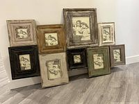 Full view of the multi picture frame showing all nine frames with various rustic finishes and sizes, standing on the floor against a white wall.