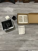 All fan components laid out including motor assembly, vent kit parts, grille cover in box and manual