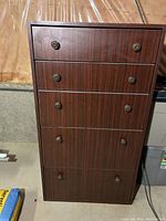 Front view of the tall boy dresser showing all five drawers and metal round pulls.