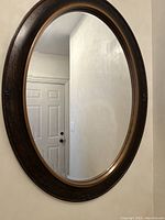Another angle of the mirror showing its depth and how the frame frames the reflective glass.