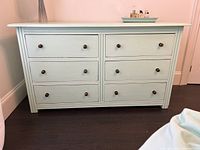 Front view of teal 6-drawer dresser against wall
