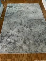 Top-down view of the full area rug showing the abstract grey pattern and rectangular shape.