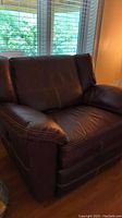 Front view of brown leather recliner against window