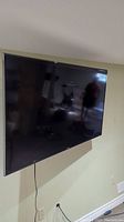Samsung TV mounted on wall showing screen and bezel