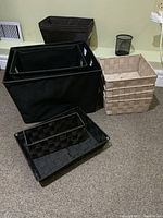 Photo showing a variety of storage baskets of different sizes and color including black cloth and beige woven basket.