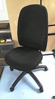 Front angle view of the black Basics upholstered adjustable task chair showing fabric seat and backrest with caster wheel base.