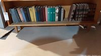 Shelf with multiple worn hardcover books in various colors and sizes.