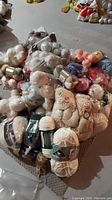 Pile of various wool yarn balls on a carpeted floor, including white, cream, green, pink, blue, and orange colors.