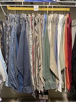 Full rack of men's dress shirts showing a range of colors and patterns in XL and XXL sizes, including blues, stripes, beiges, greens, and reds.