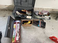 Wide view of multiple toolboxes and containers filled with assorted hand tools and hardware including wrenches, screwdrivers, and a hammer.