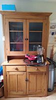 Front view of entire pine china cabinet with hutch, showing top glass doors, drawers and lower cabinet.