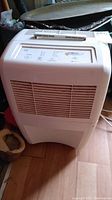 Front view of dehumidifier showing white plastic body and front air vent.