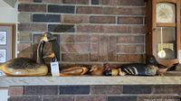 Shelf showing six wood duck decoys and bird carvings of varying sizes and colors.