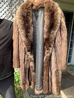 Front view of the ladies raccoon fur coat with open front to show lining