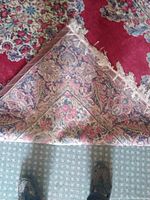 Close-up of the back side of the rug showing the woven texture and muted floral pattern.