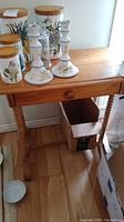 Vintage pine table with one drawer on spindle legs with turned stretcher beneath. Wooden knob on drawer. Light honey finish. Measures approximately 24x14x25 inches.