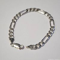 7-inch sterling silver bracelet laid out flat showing full length, chain design and lobster clasp.