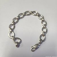 Sterling silver chain link bracelet with large oval links, lobster claw clasp, and toggle ring closure on white background.