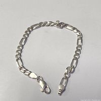 Silver 7 inch chain bracelet with lobster clasp shown fully extended on a white background.