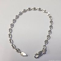 Close-up image of silver bracelet with oval-shaped links and lobster clasp, 7 inches long.