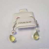 Photo of both sterling silver hoop earrings with citrine and pearl accents on a white display card stamped 'STERLING SILVER'.