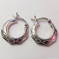 Pair of silver octagonal hoop earrings with beaded detail, latch back closures visible.