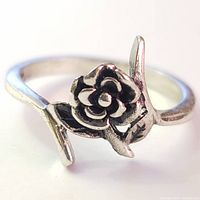Close-up front view of the sterling silver ring featuring a detailed rose flower on top with oxidized finish.