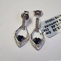 Photo showing pair of sterling silver drop earrings set with blue sapphires and white topaz stones, each earring marked 925 for sterling silver, total gemstones 1.45 carats.