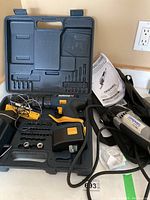 Open black carrying case showing Mastercraft cordless drill, charger, drill bits and accessories.