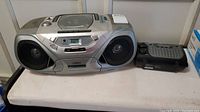Full shot of Philips AZ1035 boombox and Sylvania emergency radio on table