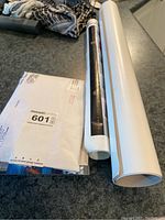 Two rolled poster sheets and mailing envelope on countertop