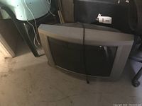 Old Philips CRT television with a curved screen and thick frame, placed on the floor showing signs of age and use.