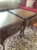 Front and top angle view of two matching wooden end tables with ornate wood grain tops, dovetailed drawers, and cabriole legs.