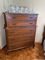 Front view of Gibbard Craftsmen highboy dresser with five drawers and decorative items on top.