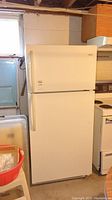 Front view of white Galaxy top freezer refrigerator, showing closed freezer and fridge doors.