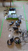 Overview of console, controllers, headsets, splitter, charge station and games spread on floor