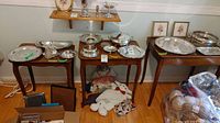 Wide shot of all three vintage nesting tables with silver serving trays and other items on top, showing size differences and overall condition.